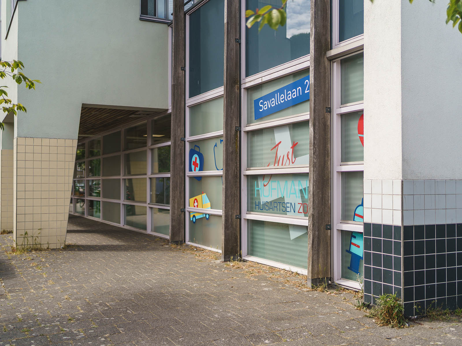 Ingang van huisartsenpraktijk Just Hofmans aan de Savallelaan 2 in Voorburg, met vlakke bestrating naar de deur